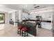 Open kitchen features an island with stool seating, stainless steel appliances, white cabinets and brick backsplash at 15471 W Post Cir, Surprise, AZ 85374