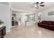 Bright open concept living room featuring tile floors, and direct views into the kitchen at 15471 W Post Cir, Surprise, AZ 85374