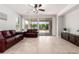 Bright living room featuring tile floors, neutral walls, and sliding glass doors to backyard at 15471 W Post Cir, Surprise, AZ 85374