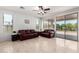 Open concept living room featuring tile floors, neutral walls, and sliding glass door to backyard at 15471 W Post Cir, Surprise, AZ 85374