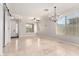 Spacious living room featuring tile floors, recessed lighting, and contemporary chandelier at 15471 W Post Cir, Surprise, AZ 85374