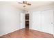 Bedroom with wood floors and a double door closet featuring a nearby open doorway to the kitchen at 16638 N 46Th Ln, Glendale, AZ 85306