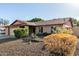 Home with a two-car garage, desert landscaping, and blooming bushes at 16638 N 46Th Ln, Glendale, AZ 85306