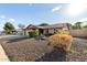 Home with a two-car garage, desert landscaping, and blooming bushes at 16638 N 46Th Ln, Glendale, AZ 85306