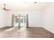 Spacious living room featuring sleek wood floors, a ceiling fan, and sliding glass doors leading to the pool at 16638 N 46Th Ln, Glendale, AZ 85306