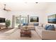 Bright living room featuring a neutral sectional sofa, modern decor, and sliding glass doors leading to a pool at 16638 N 46Th Ln, Glendale, AZ 85306