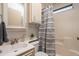 Bright bathroom with tub-shower combo, gray striped shower curtain, and built-in storage at 17200 W Bell Rd # 840, Surprise, AZ 85374