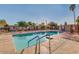 Sparkling community pool with lounge chairs, palm trees, and clear blue water at 17200 W Bell Rd # 840, Surprise, AZ 85374