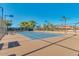 Well-maintained tennis court with a brown and blue surface, surrounded by trees and fencing at 17200 W Bell Rd # 840, Surprise, AZ 85374
