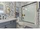Modern bathroom with patterned wallpaper, walk-in shower, and dark vanity at 17710 W Guthrie St, Surprise, AZ 85388