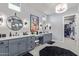 Elegant bathroom with dual vanities, modern fixtures, a decorative mirror, and a walk-in closet at 17710 W Guthrie St, Surprise, AZ 85388