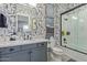 Modern bathroom with patterned wallpaper, walk-in shower, and dark vanity at 17710 W Guthrie St, Surprise, AZ 85388