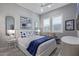 Bright bedroom featuring stylish decor, a plush bed, and shuttered windows at 17710 W Guthrie St, Surprise, AZ 85388