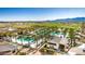 Stunning aerial view of the community pool surrounded by lush palm trees and a well-manicured golf course at 17710 W Guthrie St, Surprise, AZ 85388