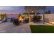 Cozy backyard patio features a fire pit, stylish seating, an outdoor dining area, and lush landscaping at 17710 W Guthrie St, Surprise, AZ 85388