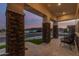 Spacious front porch featuring stone columns, tiled flooring, and comfortable outdoor seating with neighborhood views at 17710 W Guthrie St, Surprise, AZ 85388