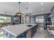 Spacious kitchen with an island, stainless steel appliances, navy blue cabinets, and an open layout to the living area at 17710 W Guthrie St, Surprise, AZ 85388