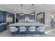 Modern kitchen featuring a large island with seating, stainless steel appliances, and blue cabinetry at 17710 W Guthrie St, Surprise, AZ 85388