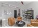 Sitting area with tufted chairs and black shelving unit with decorative items and artwork at 17710 W Guthrie St, Surprise, AZ 85388