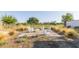 Inviting outdoor seating area with a brick patio, Adirondack chairs, and desert landscaping for relaxation and entertaining at 17710 W Guthrie St, Surprise, AZ 85388