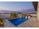 Sparkling pool with in-pool lounge chairs, hot tub, and lush landscaping at dusk at 17710 W Guthrie St, Surprise, AZ 85388