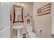 A powder room with a pedestal sink, decorative mirror, toilet, and unique wall decor at 18126 W Ocotillo Ave, Goodyear, AZ 85338