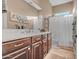 Primary bathroom with dual sink vanity, framed mirror and shower/tub combo with a white shower curtain at 18126 W Ocotillo Ave, Goodyear, AZ 85338
