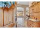 View into a spacious home with a decorative wooden front door, tile floors, and elegant furnishings at 18126 W Ocotillo Ave, Goodyear, AZ 85338