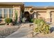 Inviting home exterior with desert landscaping, stone accents, and a charming arched entryway at 18126 W Ocotillo Ave, Goodyear, AZ 85338