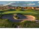 Beautiful golf course featuring a sand trap and putting green against the backdrop of desert homes at 18126 W Ocotillo Ave, Goodyear, AZ 85338