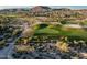 Bird's eye view of a golf course showcasing a green, desert vegetation, and mountain backdrop at 18126 W Ocotillo Ave, Goodyear, AZ 85338