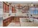 A kitchen with dark wood cabinets, granite countertops, stainless steel appliances, and tile backsplash at 18126 W Ocotillo Ave, Goodyear, AZ 85338
