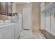 A laundry room with white appliances, built-in storage, and access to an exterior door at 18126 W Ocotillo Ave, Goodyear, AZ 85338