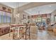 A well-lit living room with dining table, fireplace, large windows, and comfortable seating area at 18126 W Ocotillo Ave, Goodyear, AZ 85338