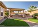 Outdoor kitchen featuring a built-in grill, bar, and pergola for shaded entertaining at 18126 W Ocotillo Ave, Goodyear, AZ 85338