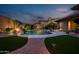 Backyard oasis featuring a sparkling pool, a waterfall feature, lush landscaping, and patio with lounge chairs at 18126 W Ocotillo Ave, Goodyear, AZ 85338