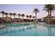 Large community pool surrounded by palm trees and lounge areas under a vibrant sky at 18126 W Ocotillo Ave, Goodyear, AZ 85338