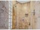 Modern shower with tiled walls, glass block window, and convenient built-in shelving at 18126 W Ocotillo Ave, Goodyear, AZ 85338