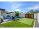 Backyard patio features stylish seating around a modern fire pit, shade cover, putting green and lush lawn at 2044 N 71St St, Scottsdale, AZ 85257