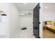 A clean and minimalist walk-in closet with a sleek black door and tiled floor at 2044 N 71St St, Scottsdale, AZ 85257