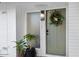Inviting front entrance with an olive-green door, a festive wreath, and decorative potted plants at 2044 N 71St St, Scottsdale, AZ 85257