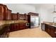 Gourmet kitchen with dark wood cabinets, tile backsplash, and stainless steel appliances at 2110 E Kerry Ln, Phoenix, AZ 85024