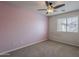 Bedroom with a pink accent wall, carpet floor, and large bright window at 2144 W Barwick Dr, Phoenix, AZ 85085