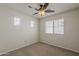 Bedroom with carpet flooring, ceiling fan, and two bright windows at 2144 W Barwick Dr, Phoenix, AZ 85085