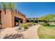 Exterior view of a community building with a curved walkway, manicured landscaping, and the US flag waving at 2144 W Barwick Dr, Phoenix, AZ 85085