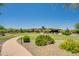 Exterior view of a community building with curved walkway, green grass, desert landscaping, and the US flag waving at 2144 W Barwick Dr, Phoenix, AZ 85085