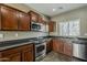 Modern kitchen features stainless appliances, dark cabinetry, and granite countertops at 2144 W Barwick Dr, Phoenix, AZ 85085