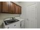 Laundry room with a front load washer and dryer, with wood grain cabinets at 2144 W Barwick Dr, Phoenix, AZ 85085