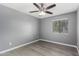Neutral bedroom featuring modern ceiling fan, wood-look floors, and window at 2146 W Isabella Ave # 127, Mesa, AZ 85202