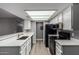Clean kitchen featuring white cabinets, updated countertops, and black appliances at 2146 W Isabella Ave # 127, Mesa, AZ 85202